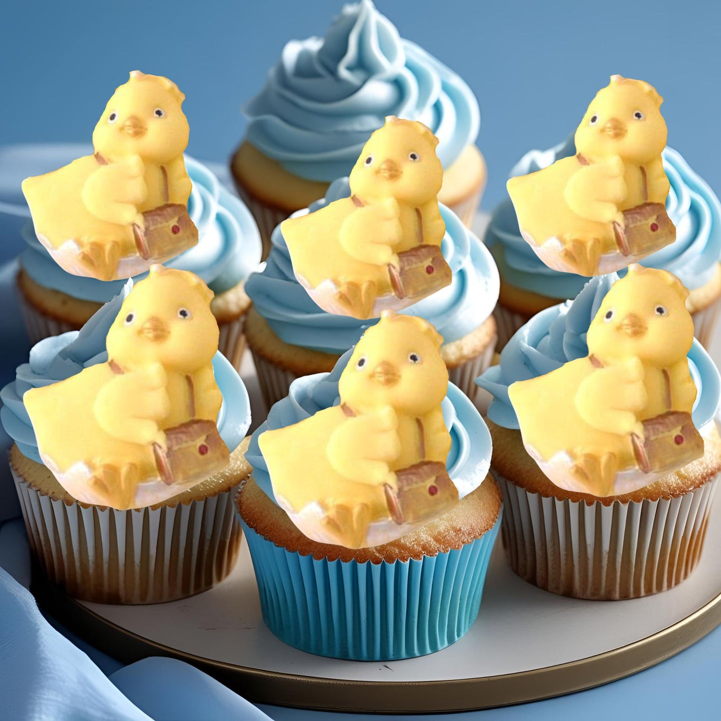 Cupcakes with blue frosting with yellow duck carrying bag decorations on a tray.