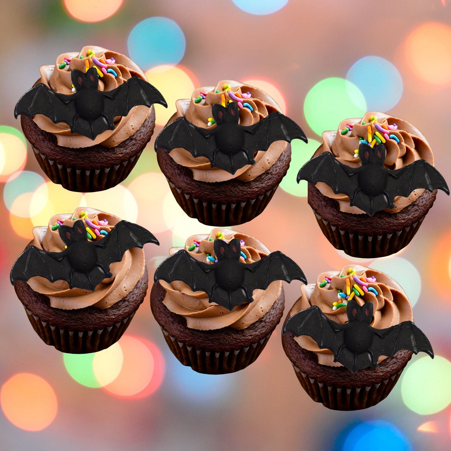Chocolate cupcakes with brown frosting and black bat edible decorations on a colorful lights background