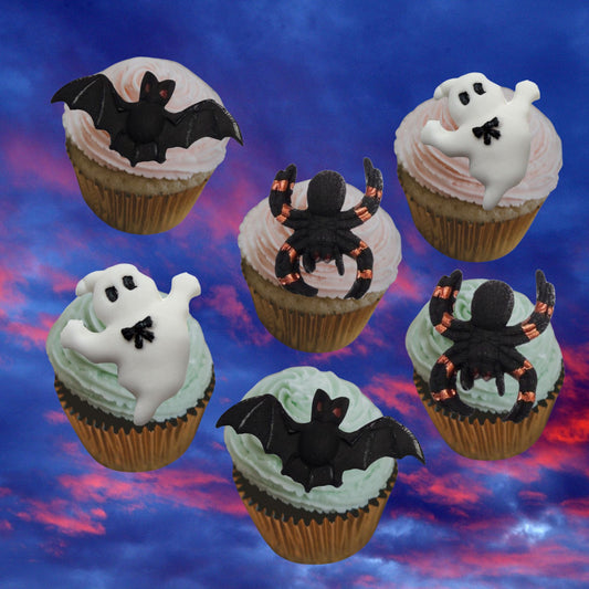 Halloween-themed cupcakes with bats, ghosts, and spiders on a colorful background