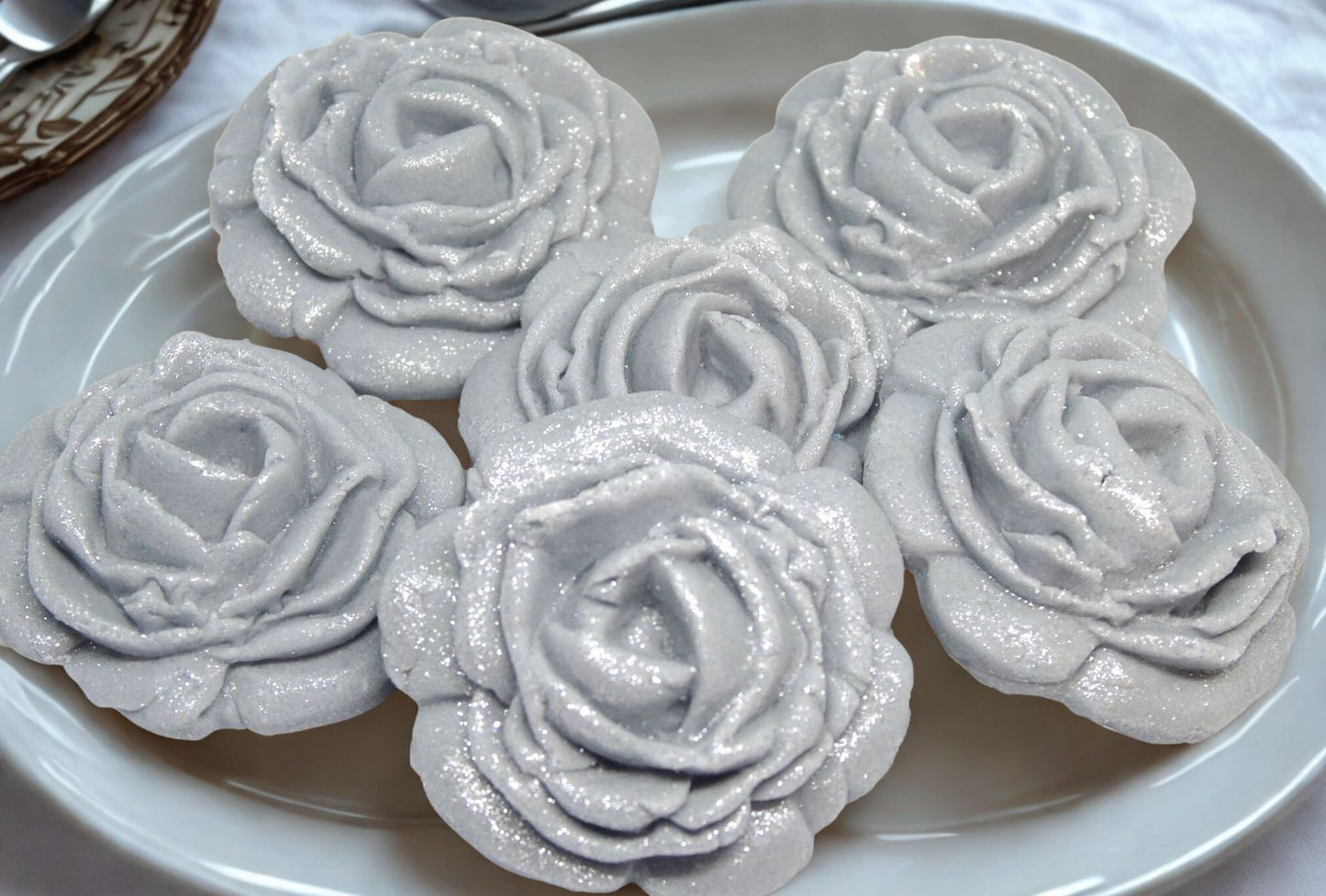 Silver rose-edible decorations on a white plate