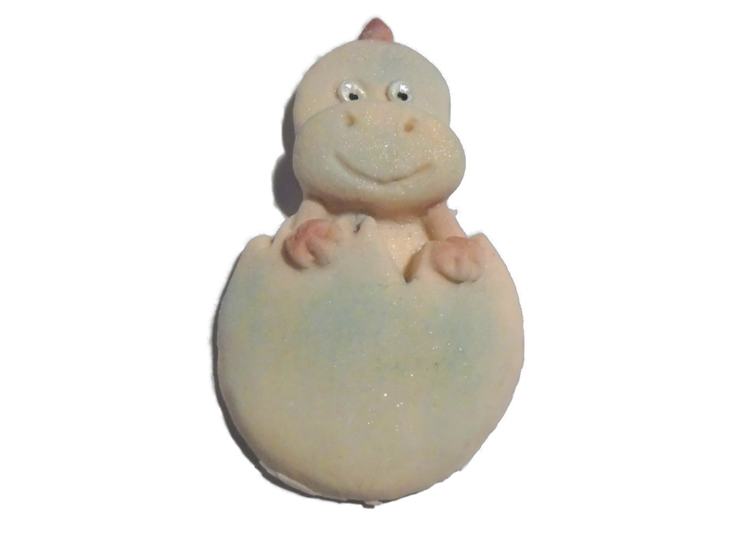 Dinosaur cake topper emerging from an egg on a white background