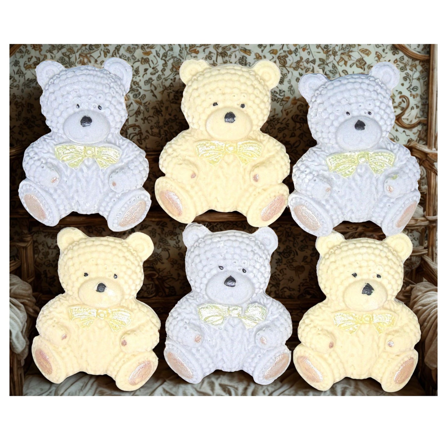 Set of cream and grey colored edible teddy bears cake toppers with bow ties on a wooden shelf.
