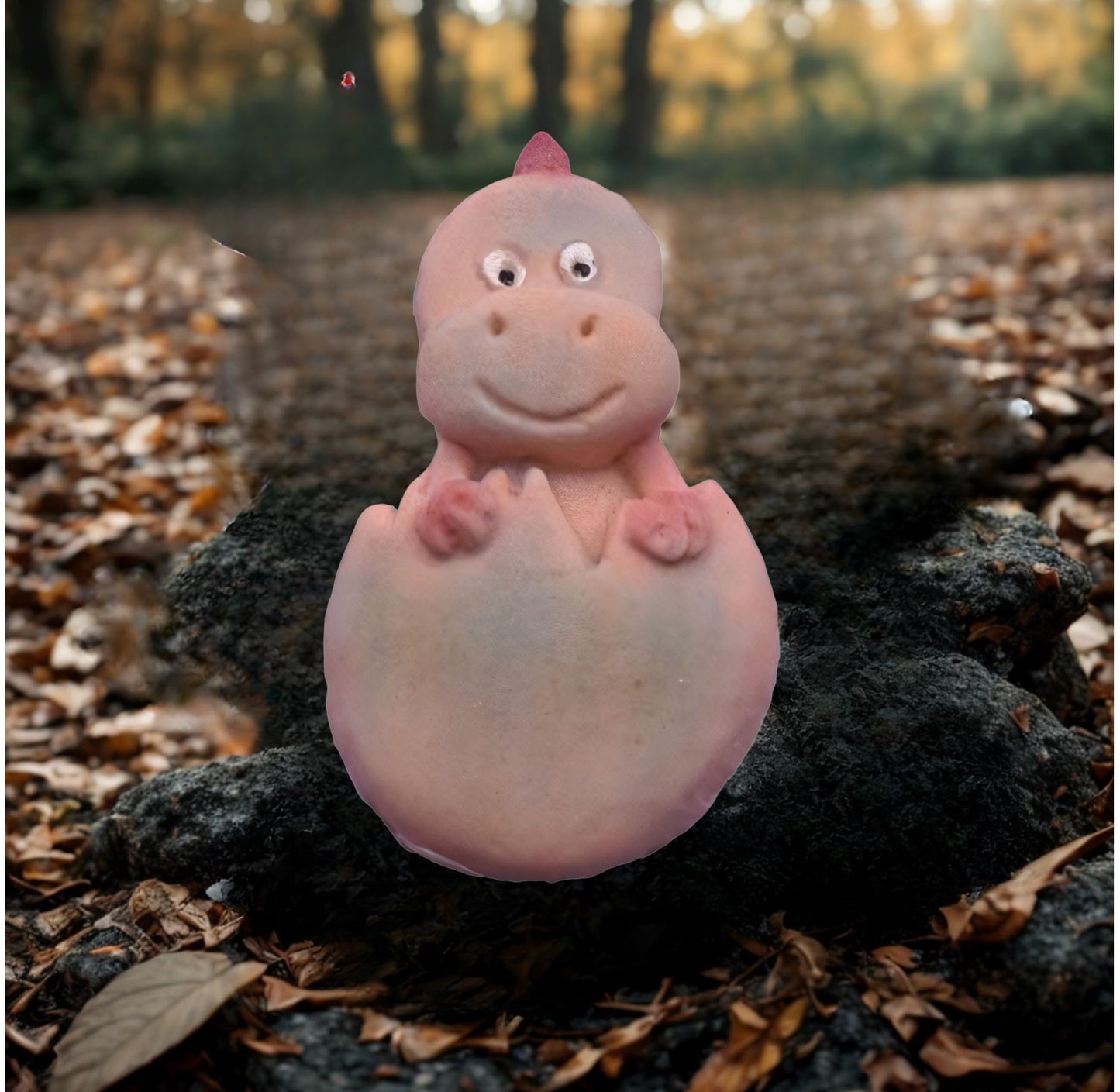 Baby dinosaur cake decorations in egg shown in natural woodland