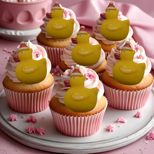 Cupcakes with yellow sugar paste Christmas duck decorations on a pink surface