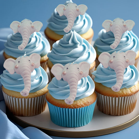 Cupcakes with blue frosting and elephant face decorations on a plate.