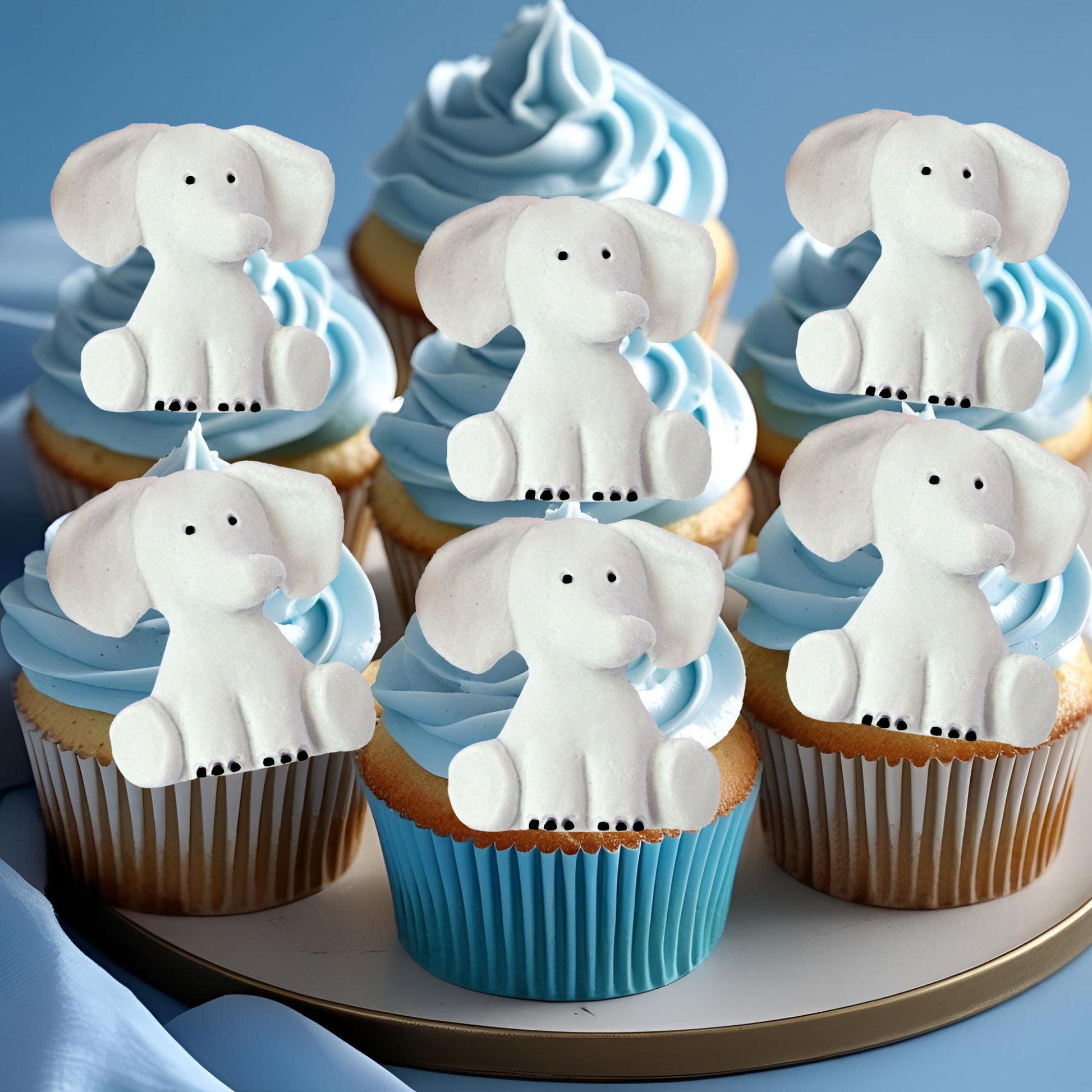 Cupcakes with grey elephant toppers on a blue background