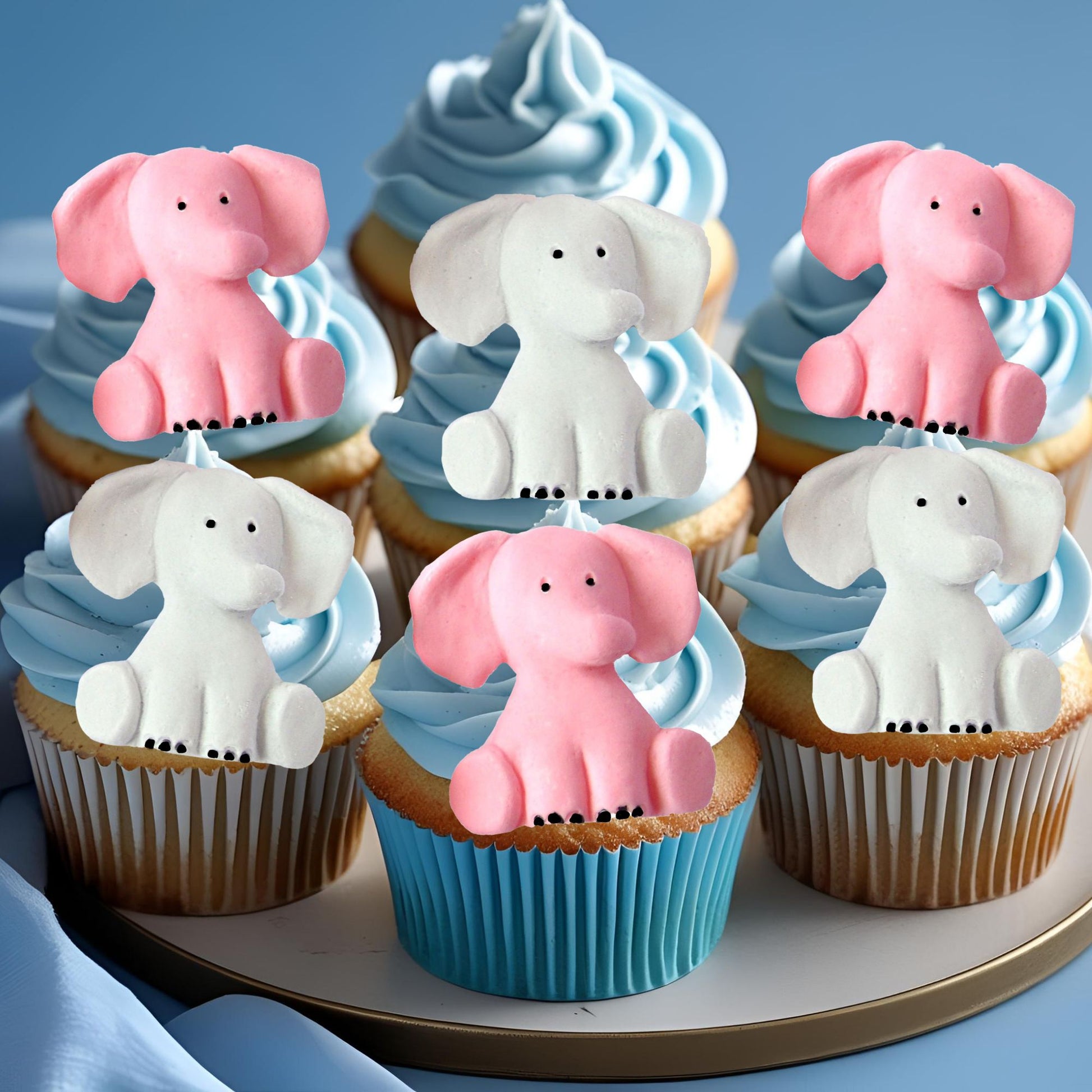 Cupcakes with pink and grey elephant toppers on a blue background