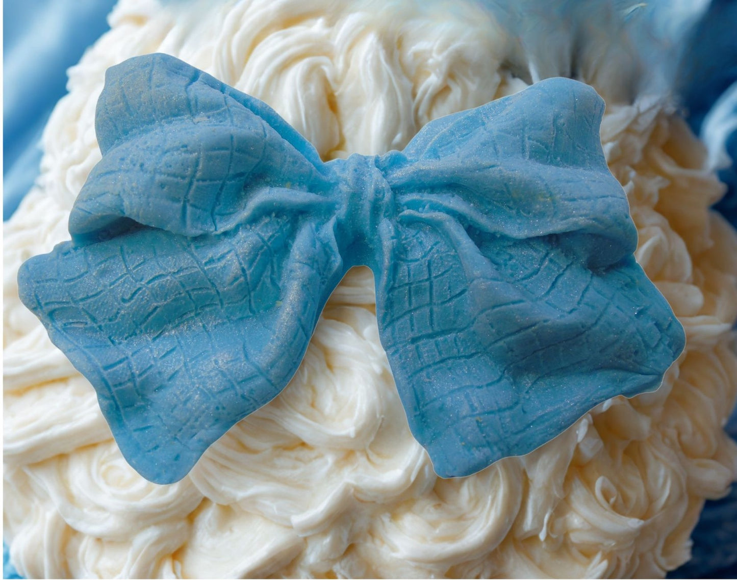 large Blue glittered edible bow on a white cake