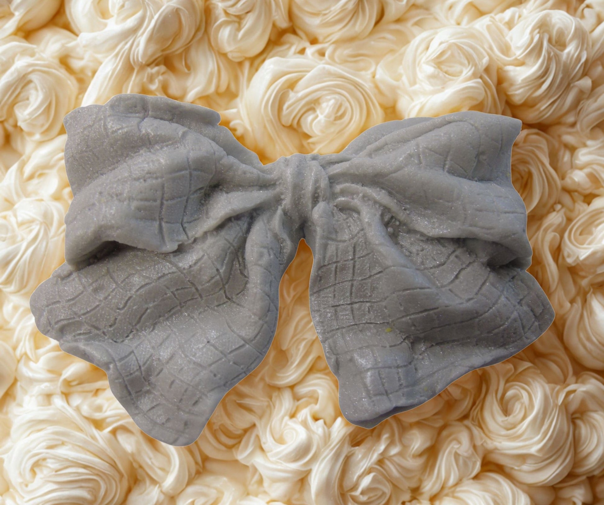 large Silver glittered edible bow on a white cake