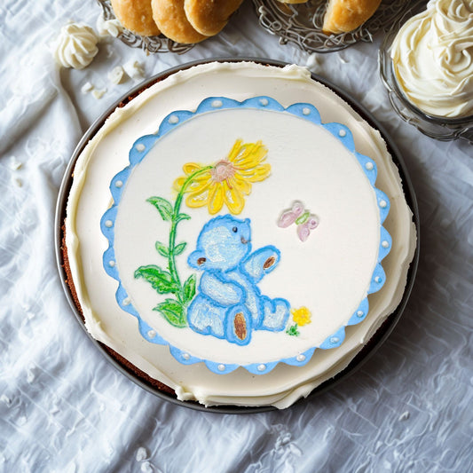Blue Teddy cake topper on top of a cream cake