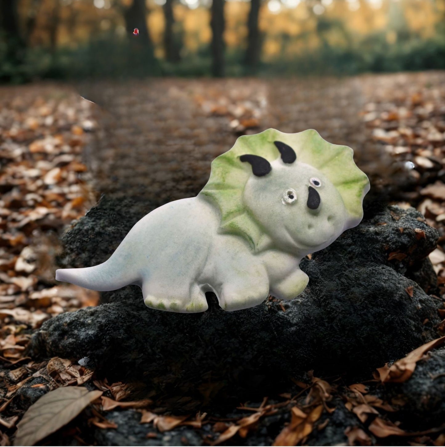 Cute  dinosaur cake toppers on a rock with a forest background